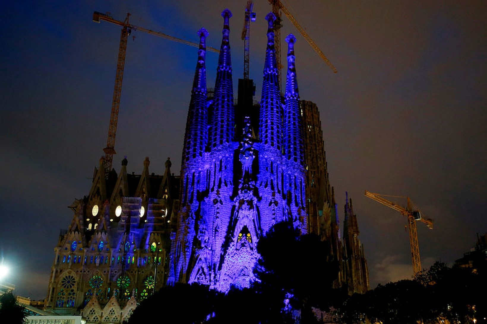 Sagrada Familia kirkjan í Barcelona lýst upp í bláum lit …