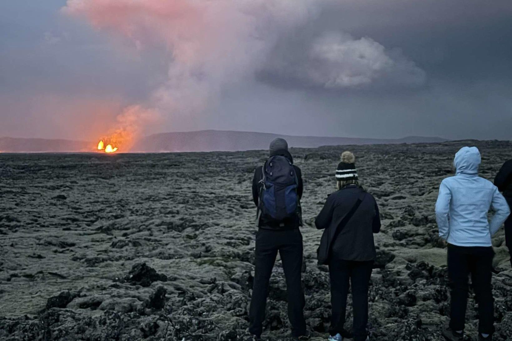 Ferðamenn virða fyrir sér eldgosið við Sundhnúkagíga.