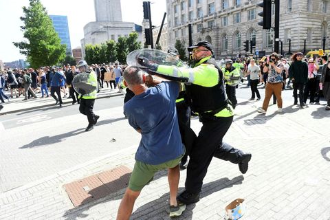 Lögregluþjónn og mótmælandi takast á í Liverpool þar sem fólk kom saman í kjölfar stunguárásarinnar.